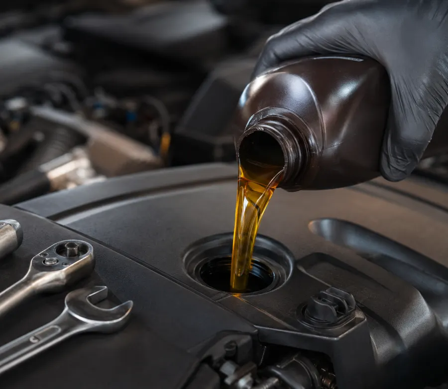 Fresh oil being poured into a vehicle engine during an oil change